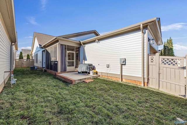 rear view of house featuring cooling unit, a yard, a patio area, and a sunroom