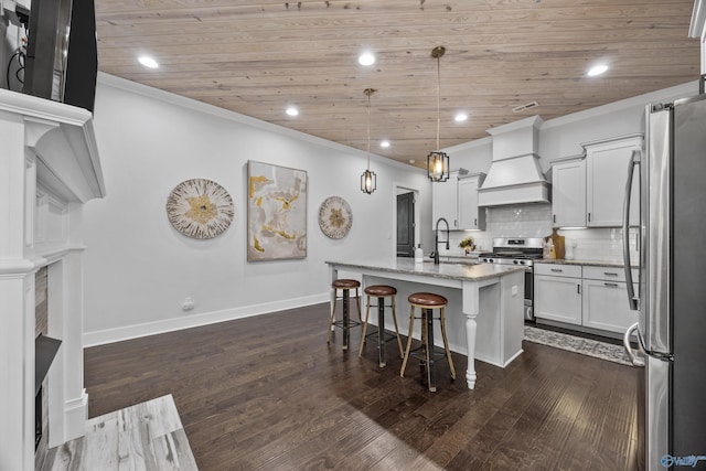 kitchen with premium range hood, decorative light fixtures, an island with sink, sink, and stainless steel appliances