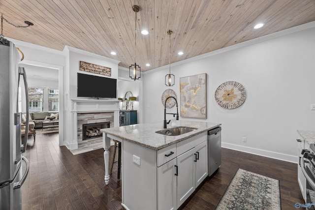 kitchen featuring sink, light stone counters, an island with sink, pendant lighting, and stainless steel appliances