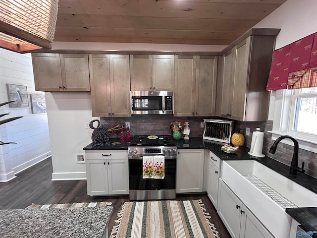 kitchen featuring sink, dark hardwood / wood-style floors, decorative backsplash, white cabinets, and appliances with stainless steel finishes