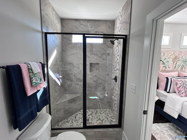 bathroom featuring toilet and an enclosed shower