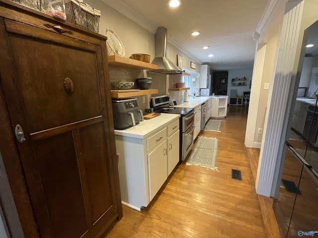 kitchen featuring white cabinetry, appliances with stainless steel finishes, light hardwood / wood-style floors, and wall chimney exhaust hood