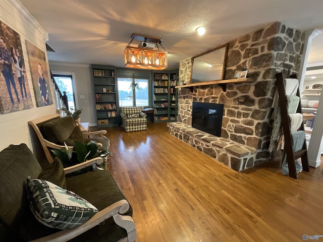 living room featuring hardwood / wood-style flooring, crown molding, and a fireplace