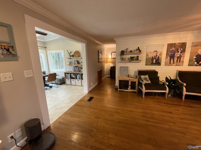 sitting room with wood-type flooring and ornamental molding