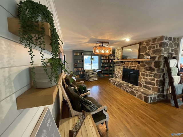 living room featuring wood-type flooring and a stone fireplace