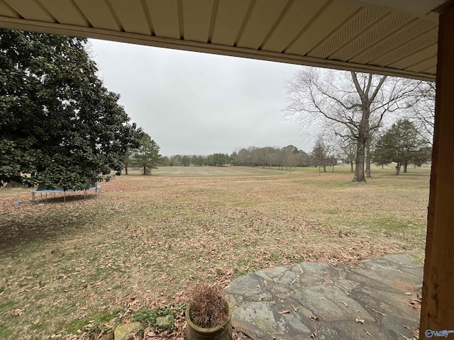 view of yard featuring a rural view and a trampoline