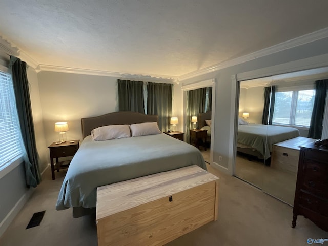 bedroom with two closets, ornamental molding, and light colored carpet