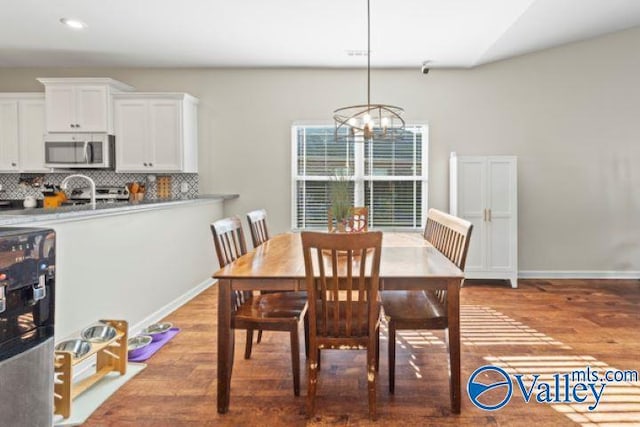 dining space featuring hardwood / wood-style flooring and a chandelier