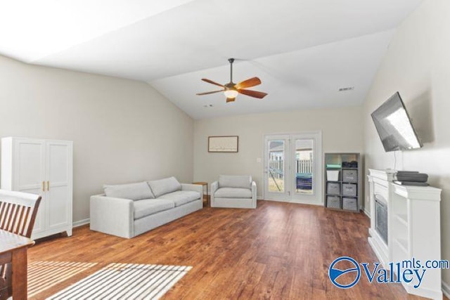 unfurnished living room with ceiling fan, vaulted ceiling, and wood-type flooring