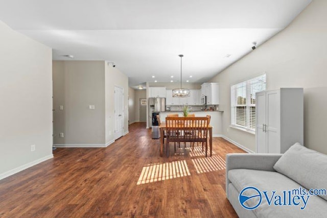 dining area with dark hardwood / wood-style flooring and a chandelier