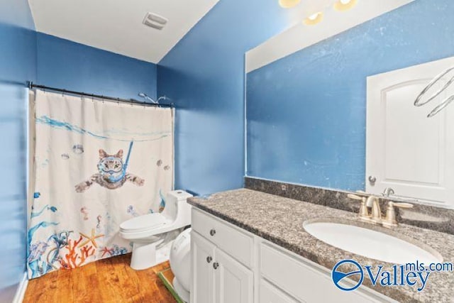 bathroom featuring vanity, hardwood / wood-style floors, curtained shower, and toilet