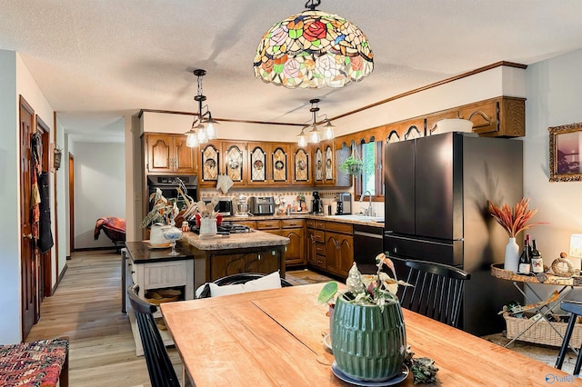 3103 Burningtree Mountain Rd, Decatur, AL 35603 - kitchen with black appliances, a sink, light countertops, brown cabinetry, and a textured ceiling
