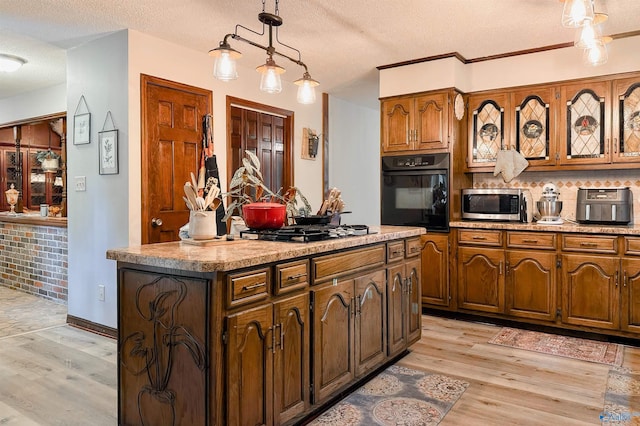 3103 Burningtree Mountain Rd, Decatur, AL 35603 - kitchen with oven, stainless steel microwave, light wood finished floors, a textured ceiling, and a kitchen island