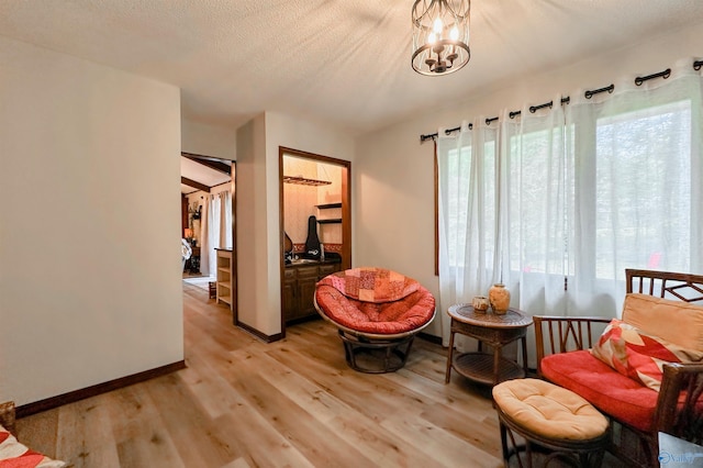 3103 Burningtree Mountain Rd, Decatur, AL 35603 - sitting room featuring light wood-type flooring, baseboards, a chandelier, and a textured ceiling