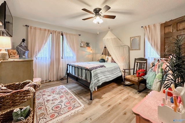 3103 Burningtree Mountain Rd, Decatur, AL 35603 - bedroom featuring multiple windows, light wood-style floors, ceiling fan, and a textured ceiling