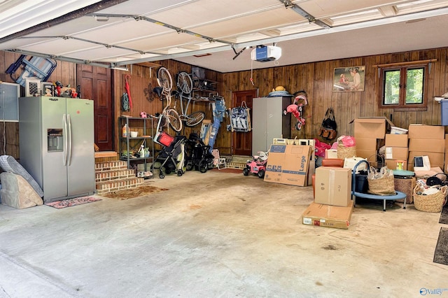 3103 Burningtree Mountain Rd, Decatur, AL 35603 - garage featuring stainless steel fridge, a garage door opener, and wooden walls