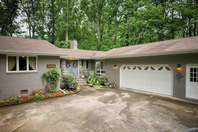 3103 Burningtree Mountain Rd, Decatur, AL 35603 - ranch-style home with brick siding, concrete driveway, a chimney, a shingled roof, and an attached garage