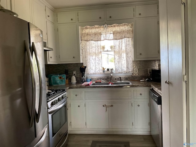 kitchen with ventilation hood, stainless steel appliances, decorative backsplash, and a sink