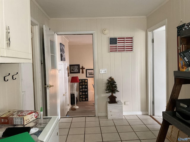 corridor with crown molding, baseboards, and light tile patterned flooring
