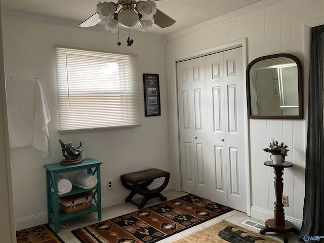 foyer featuring crown molding, tile patterned floors, ceiling fan, and visible vents