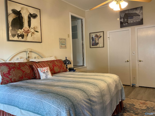 bedroom with ornamental molding, a ceiling fan, and wood finished floors