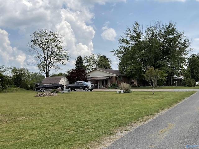 view of front of home with curved driveway and a front yard