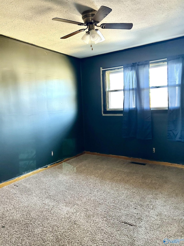 unfurnished room with carpet, ceiling fan, and a textured ceiling