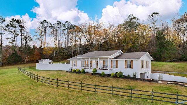 view of front of home featuring a front lawn, covered porch, a rural view, and a garage