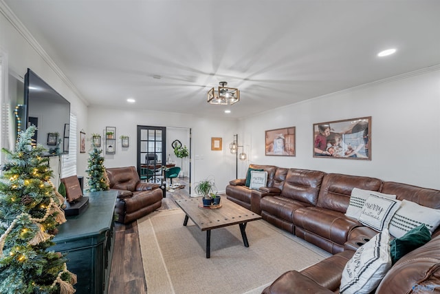 living room with an inviting chandelier, wood-type flooring, and ornamental molding