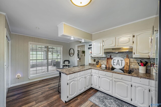 kitchen featuring kitchen peninsula, black electric cooktop, white cabinets, and dark wood-type flooring