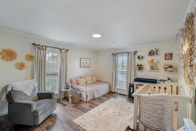 bedroom featuring multiple windows, crown molding, and hardwood / wood-style floors