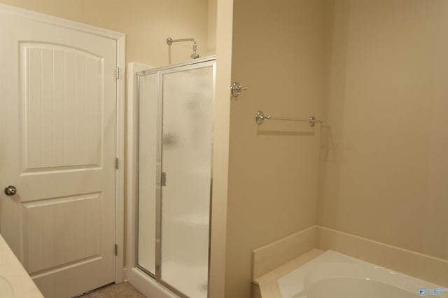 full bathroom featuring a stall shower and a bath