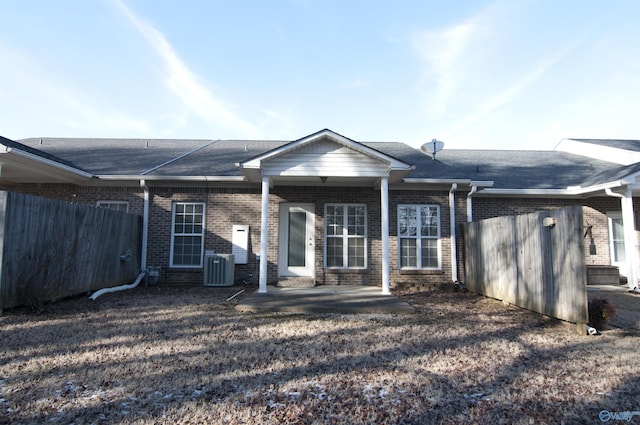 back of house featuring brick siding, a patio area, fence, and a shingled roof