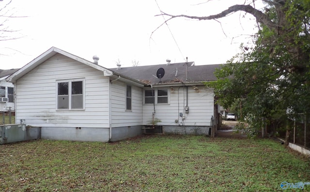 back of property featuring crawl space and a lawn