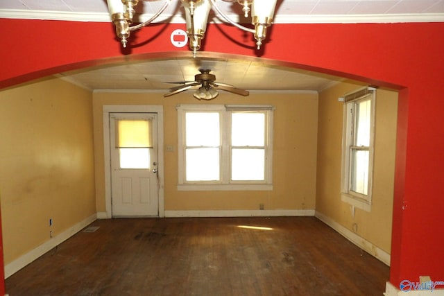 interior space with arched walkways, ornamental molding, wood finished floors, and baseboards