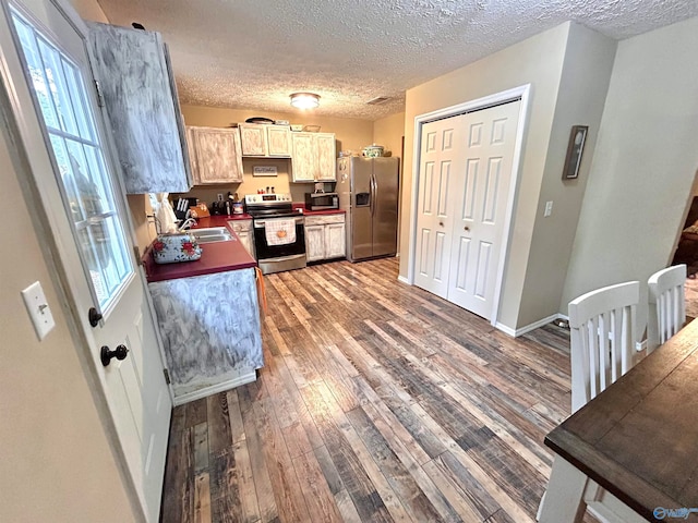 kitchen featuring appliances with stainless steel finishes, a textured ceiling, hardwood / wood-style flooring, and plenty of natural light