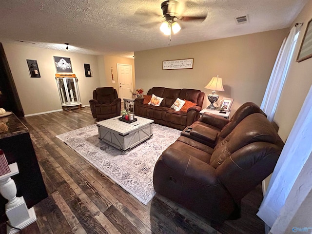 living room featuring a textured ceiling, dark hardwood / wood-style flooring, and ceiling fan