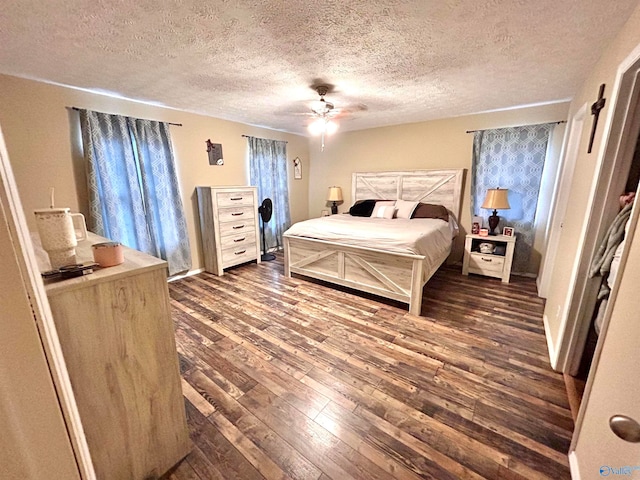 bedroom featuring dark wood-type flooring, a textured ceiling, and ceiling fan