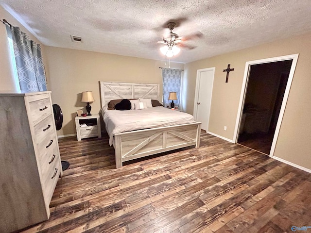 bedroom with dark wood-type flooring, ceiling fan, a textured ceiling, and a closet