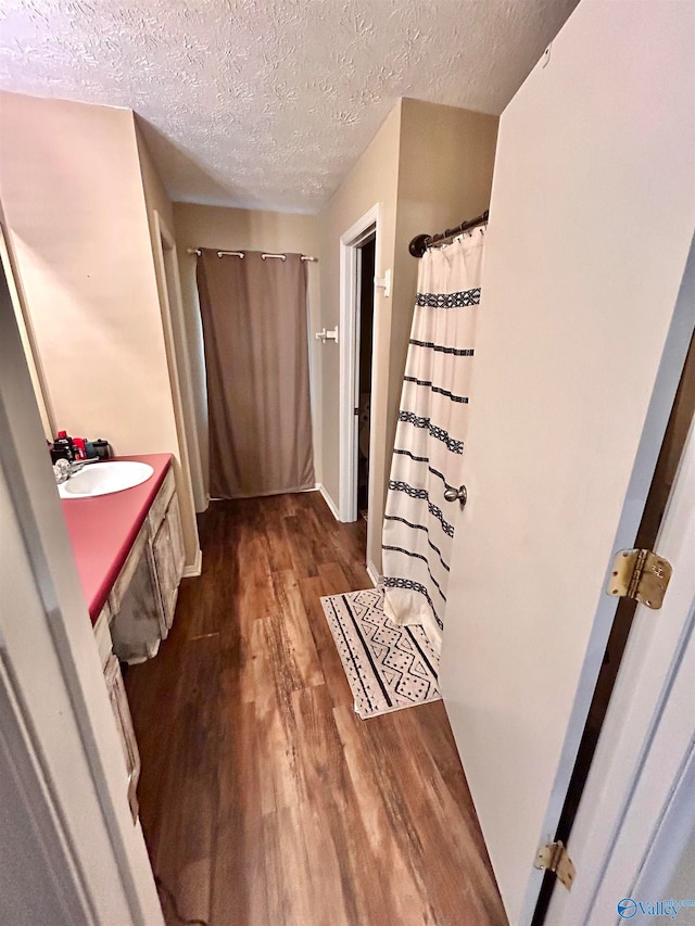 bathroom with vanity, hardwood / wood-style flooring, and a textured ceiling