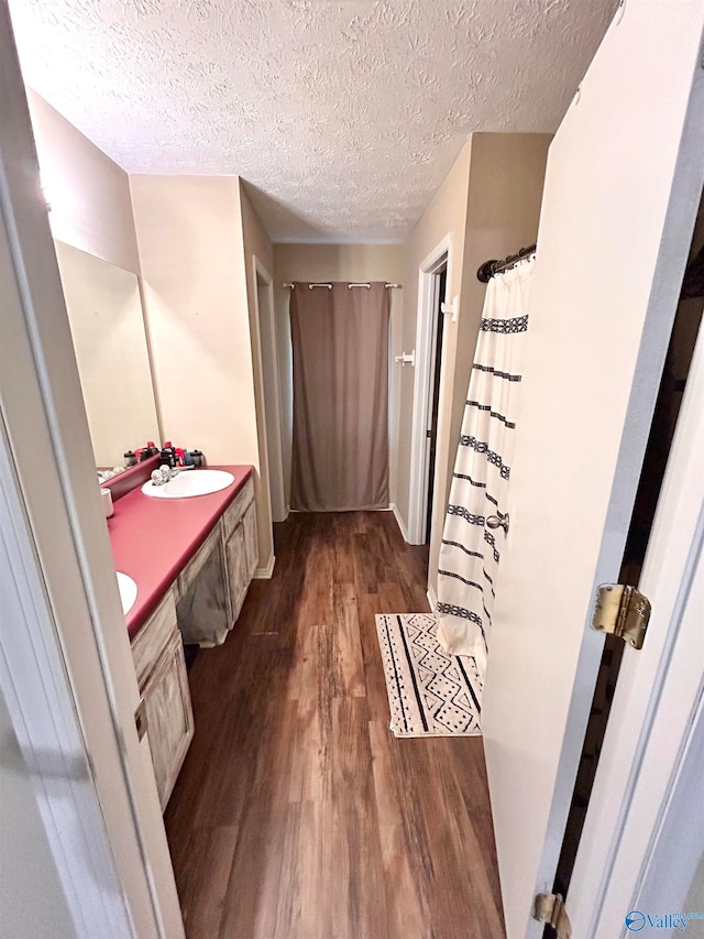 bathroom featuring wood-type flooring, a textured ceiling, and vanity