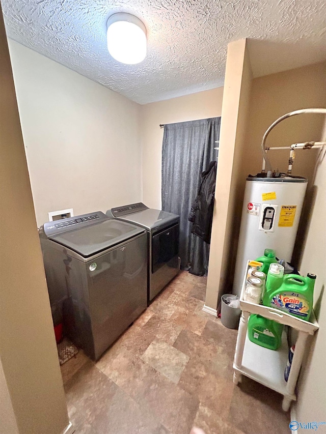 laundry area with separate washer and dryer, a textured ceiling, and water heater