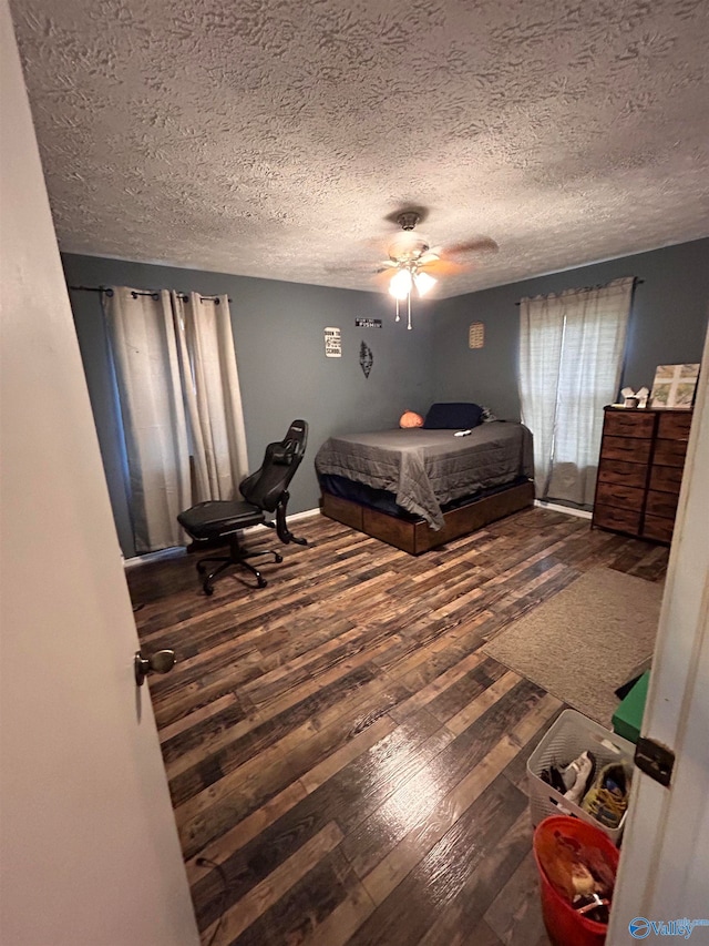 bedroom featuring a textured ceiling, wood-type flooring, and ceiling fan