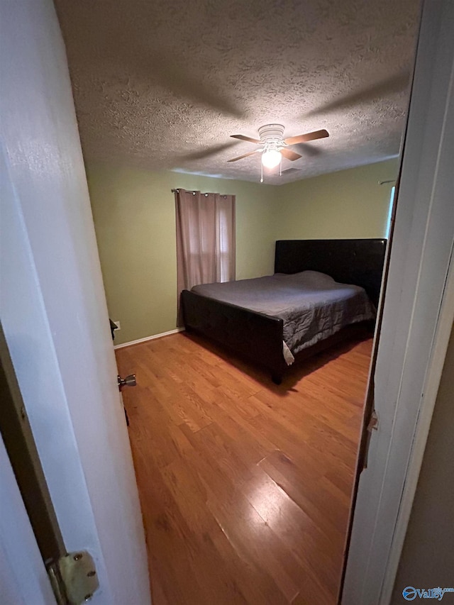 unfurnished bedroom with ceiling fan, a textured ceiling, and light hardwood / wood-style flooring