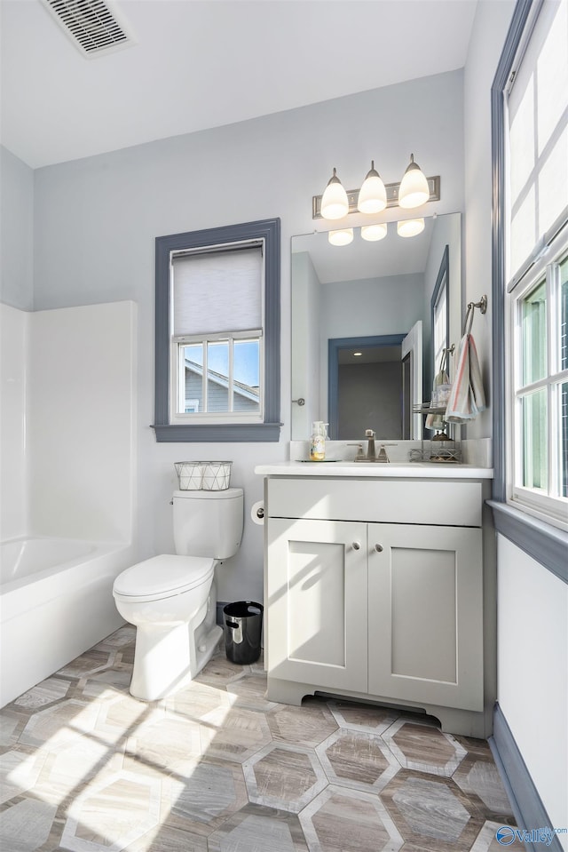 bathroom with vanity, a wealth of natural light, and toilet