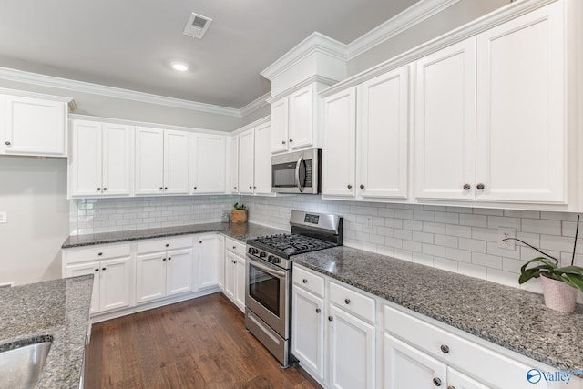 kitchen with visible vents, dark wood finished floors, white cabinetry, stainless steel appliances, and crown molding