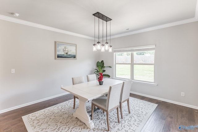 dining room with dark wood-style floors, visible vents, baseboards, and ornamental molding