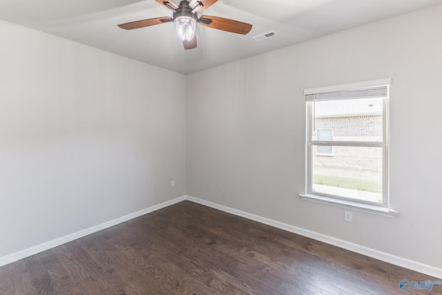 unfurnished room with visible vents, dark wood-type flooring, and baseboards