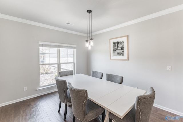 dining area featuring visible vents, baseboards, dark wood finished floors, and crown molding