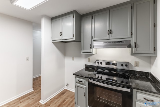 kitchen with stainless steel range with electric stovetop, light hardwood / wood-style flooring, and gray cabinetry